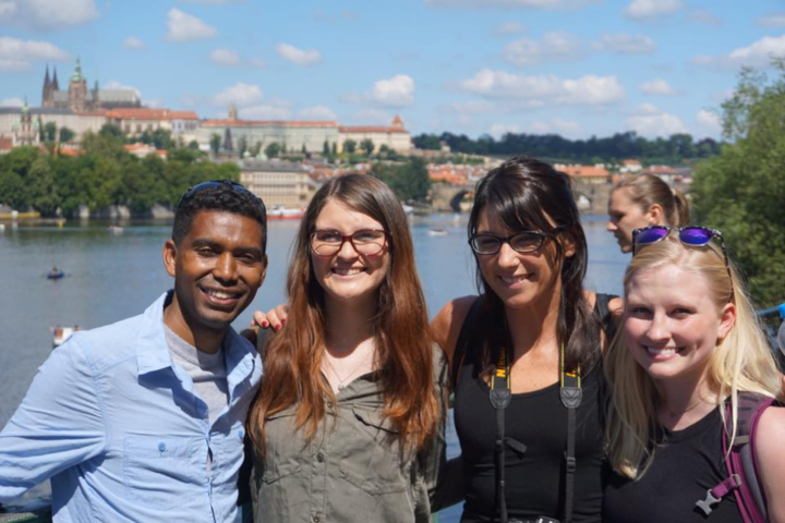 Group of people standing in front of river and building