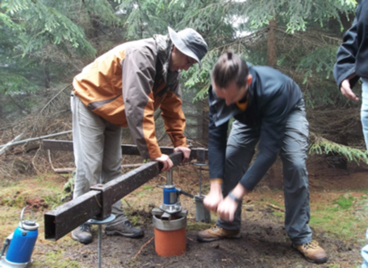 Two people working on object in ground